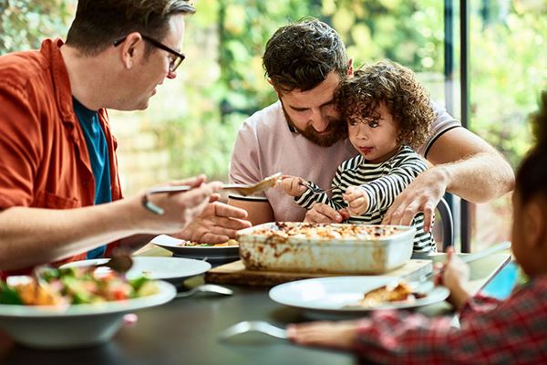 fathers feeding young children family dinner at home fathers feeding young children family dinner at home